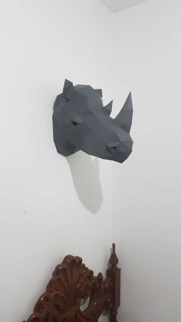 cabeça de rinoceronte na parede acima da cama