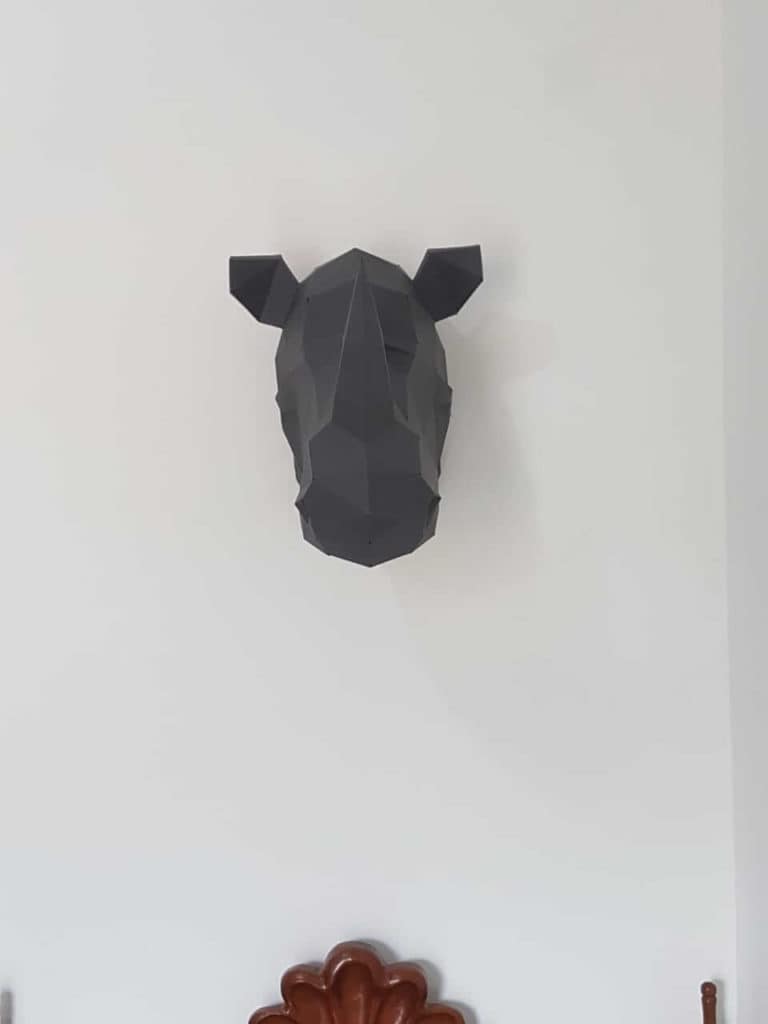 cabeça de rinoceronte na parede acima da cama
